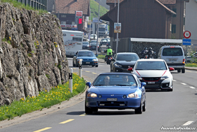 Verschiedene Hondas fahren aus einem Dorf 