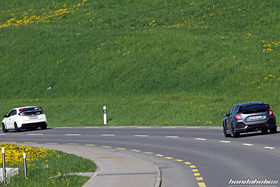 Weisser Civic Type R FK2 und grauer FK8 von hinten auf einer Landstrasse 